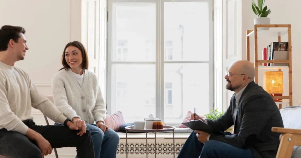 Life coach listening to a couple during a calm coaching or therapy session in a bright, peaceful room.