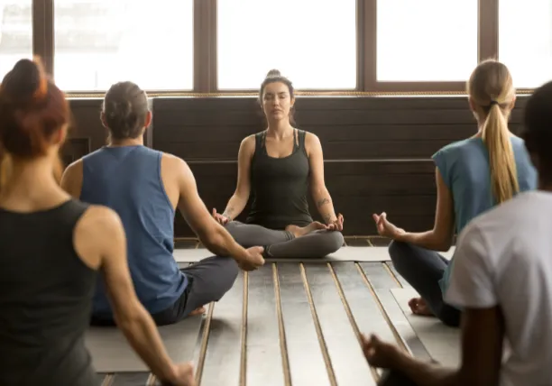 Group practicing meditation together indoors for clarity and focus